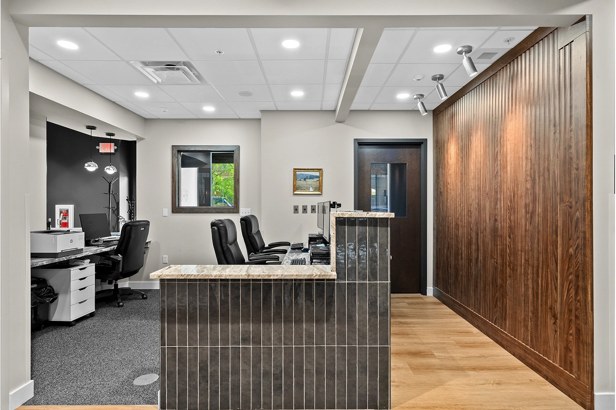 Side view of dental office reception area with front desk and seating space